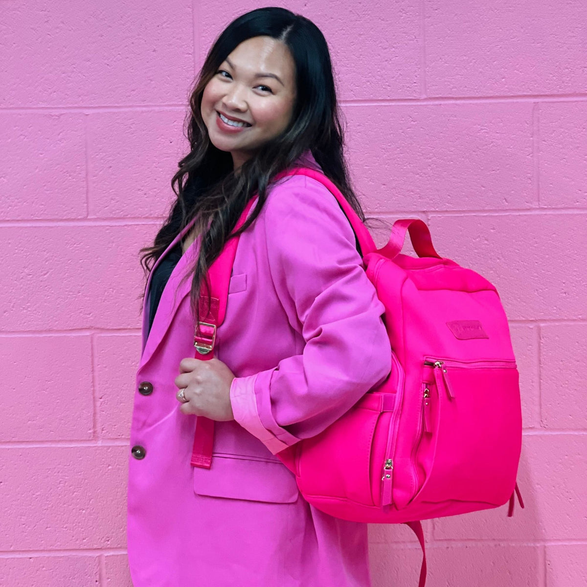 Woman wearing the Sarah Wells Fiona pump backpack in hot pink