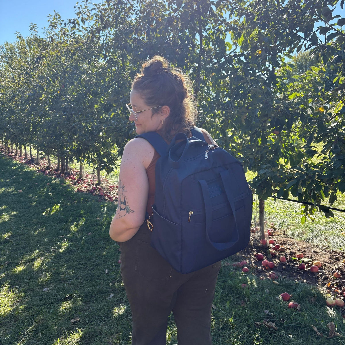 Woman wearing the Sarah Wells Kelly pump bag in Indigo as a backpack