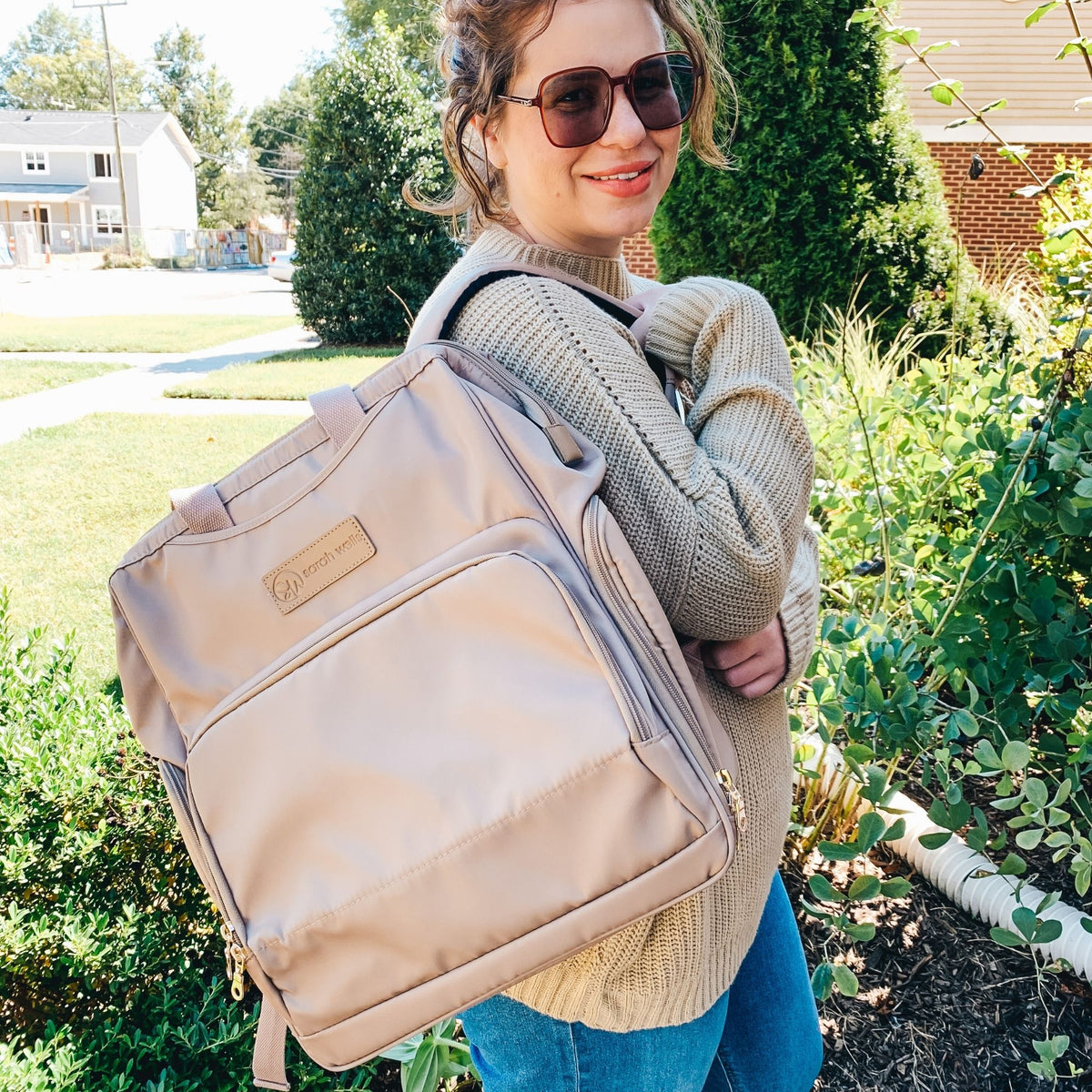 Woman wearing the Sarah Wells Norah pump backpack in latte as a backpack or carrying it as a tote