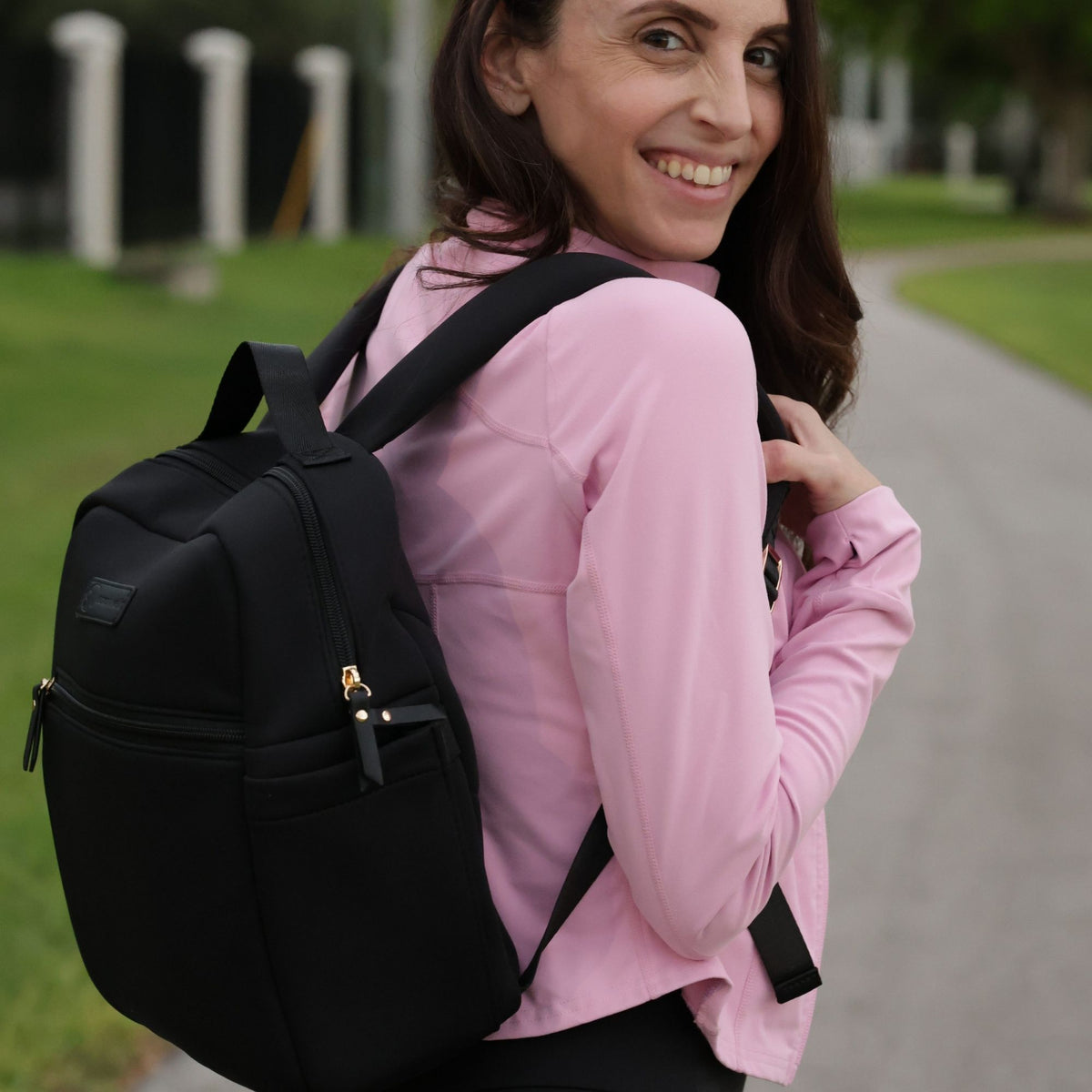 Woman wearing the Sarah Wells Fifi mini pump backpack in black as a mini backpack or diaper bag
