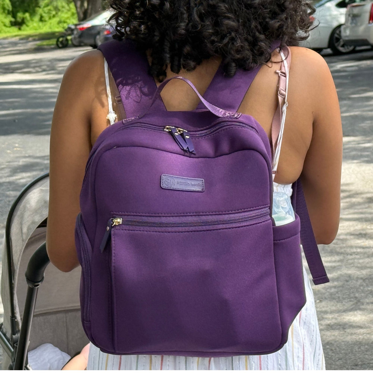 Woman wearing the Sarah Wells Fifi mini pump backpack in Purple as a mini backpack or diaper bag