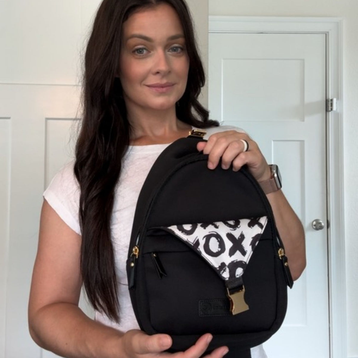 Woman holding the Sarah Wells Allie pump sling in Black
