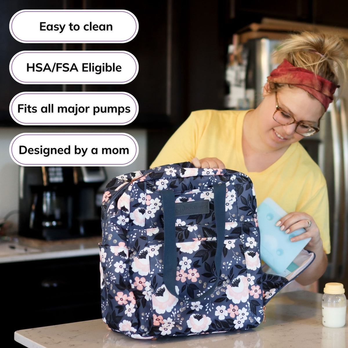 Woman carrying the Sarah Wells Kelly pump bag in le floral, with badges for easy to clean, HSA/FSA eligible, fits all major pumps, and designed by a mom